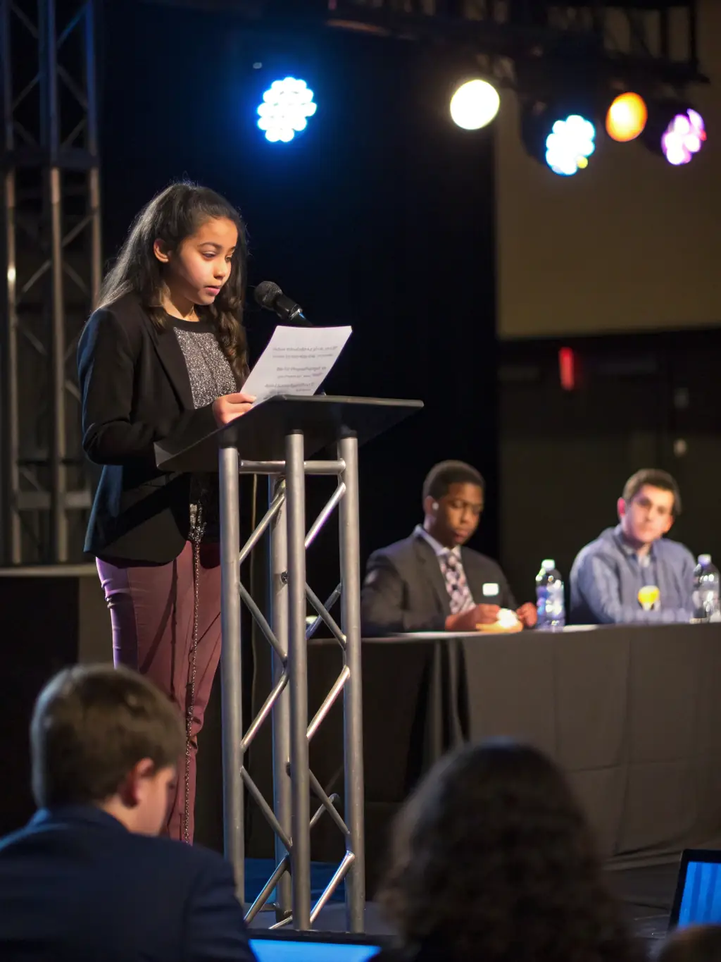 A photograph capturing a keynote speaker passionately addressing a large audience at the Innovation Summit UK 2024, with the summit logo prominently displayed in the background.